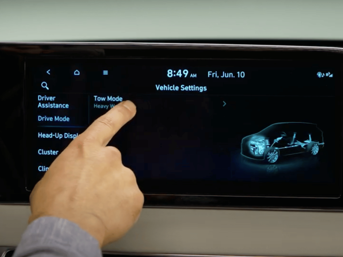 Driver selects Tow Mode on the 2025 Hyundai Palisade's touchscreen, showcasing advanced towing settings.