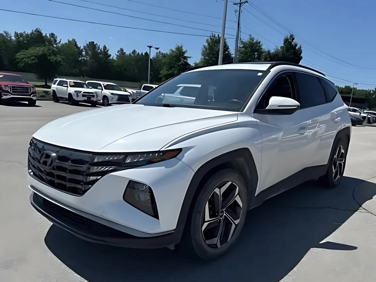 White used Hyundai Tucson SUV parked at Crain Hyundai of Fayetteville under sunny sky