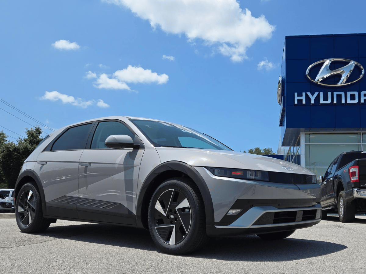 2025 Hyundai Ioniq 5 electric SUV parked outside Hyundai Crain Fayetteville AR under a bright blue sky