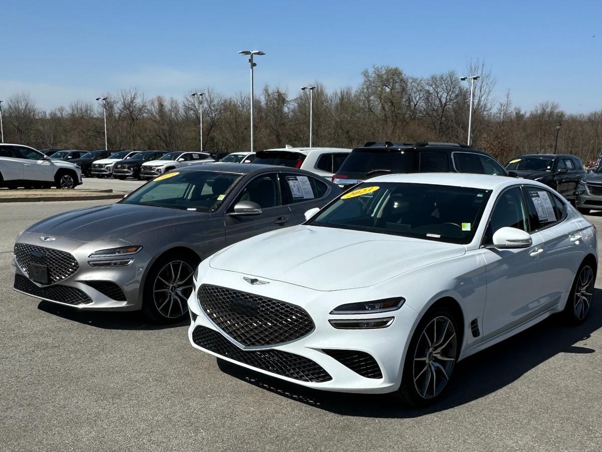 Silver and white Genesis sedans parked at Crain Hyundai of Fayetteville, where local drivers can sell or trade vehicles through the Crain Buys Cars program.