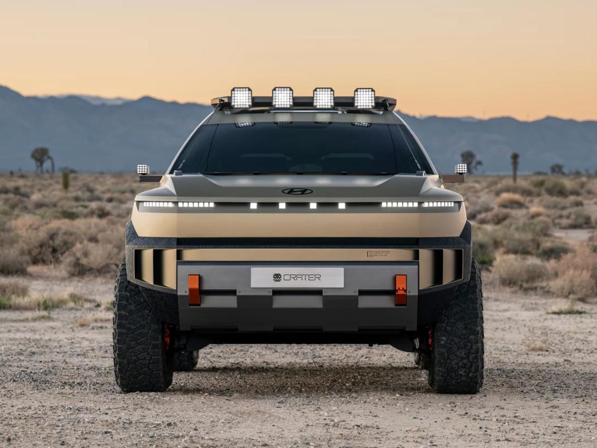 Front view of the Hyundai CRATER Concept featuring a panoramic pixel light bar, roof-mounted auxiliary lights, and orange-accented recovery hooks.